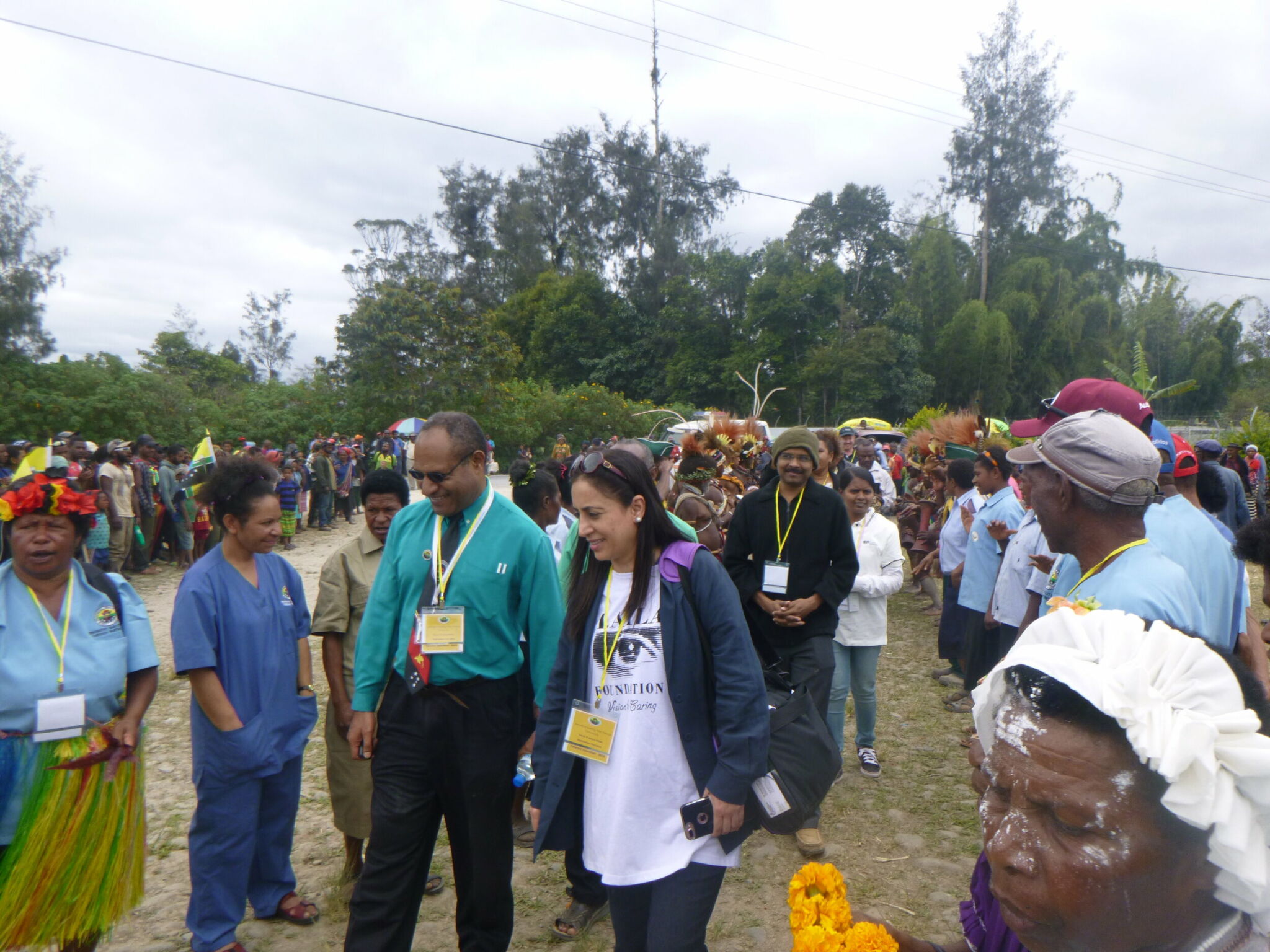 Two doctors walking and being welcomed by the local community