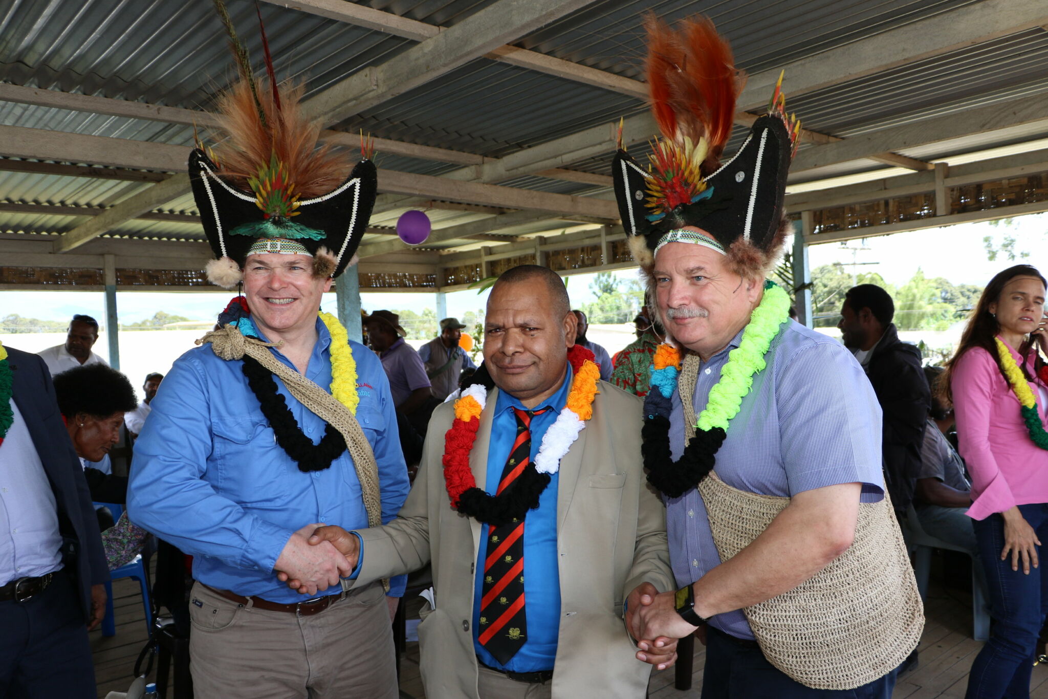 Santos CEO Kevin Gallagher, Governor Hela Province Philip Undialu and Oil Search Managing Director Peter Botten in traditional head dress.
