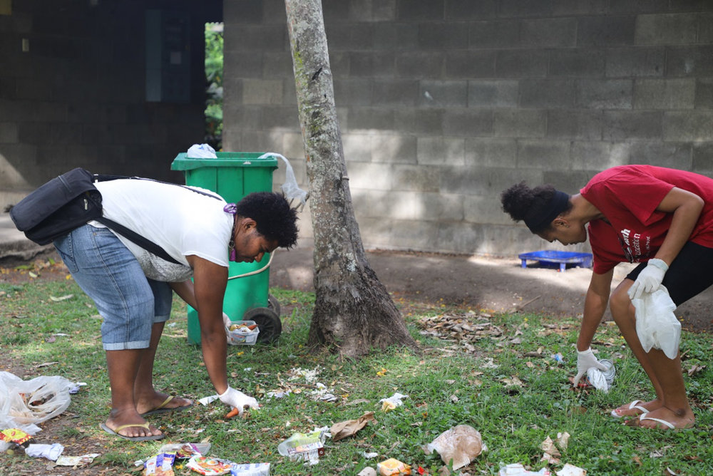 Students picking up rubbish and placing into bags