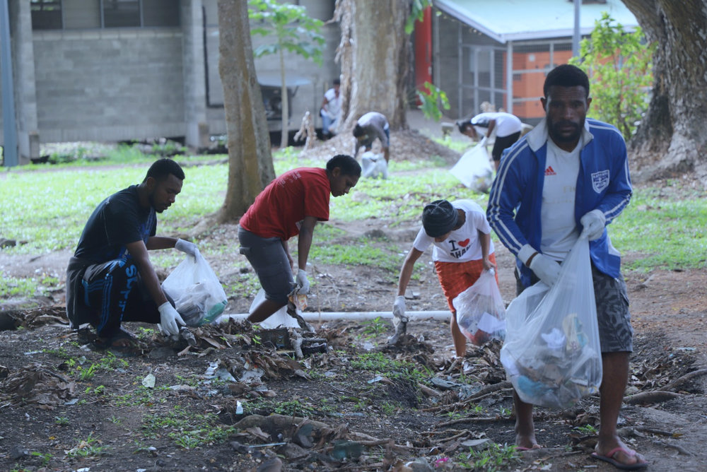 Students picking up rubbish in front of campus